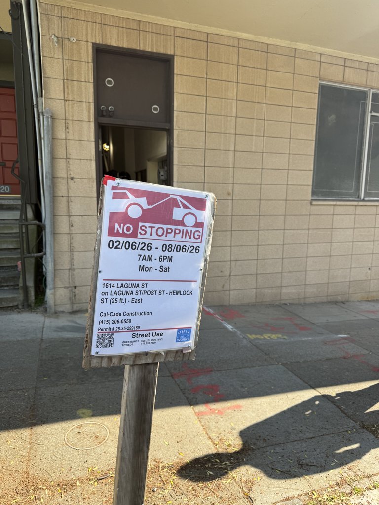 A real, slightly tilted SF no-stopping sign photographed on the street
